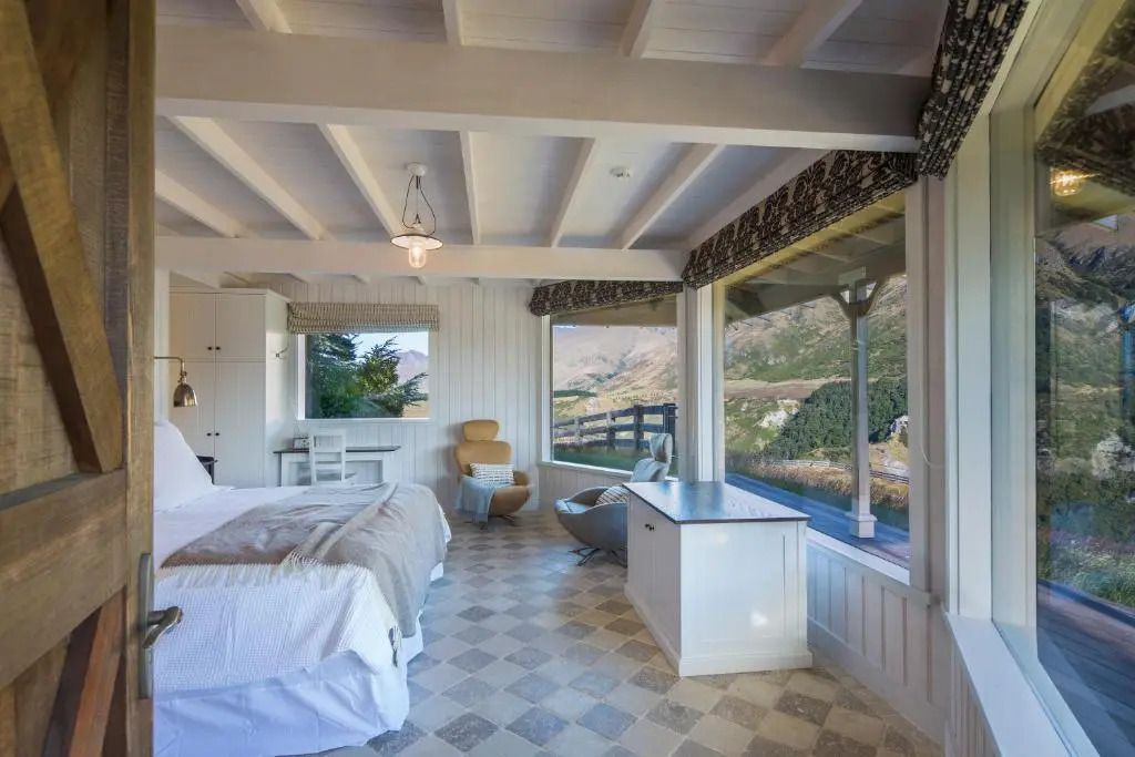 Helles Schlafzimmer mit großem Bett und Panoramafenstern zu Bergen