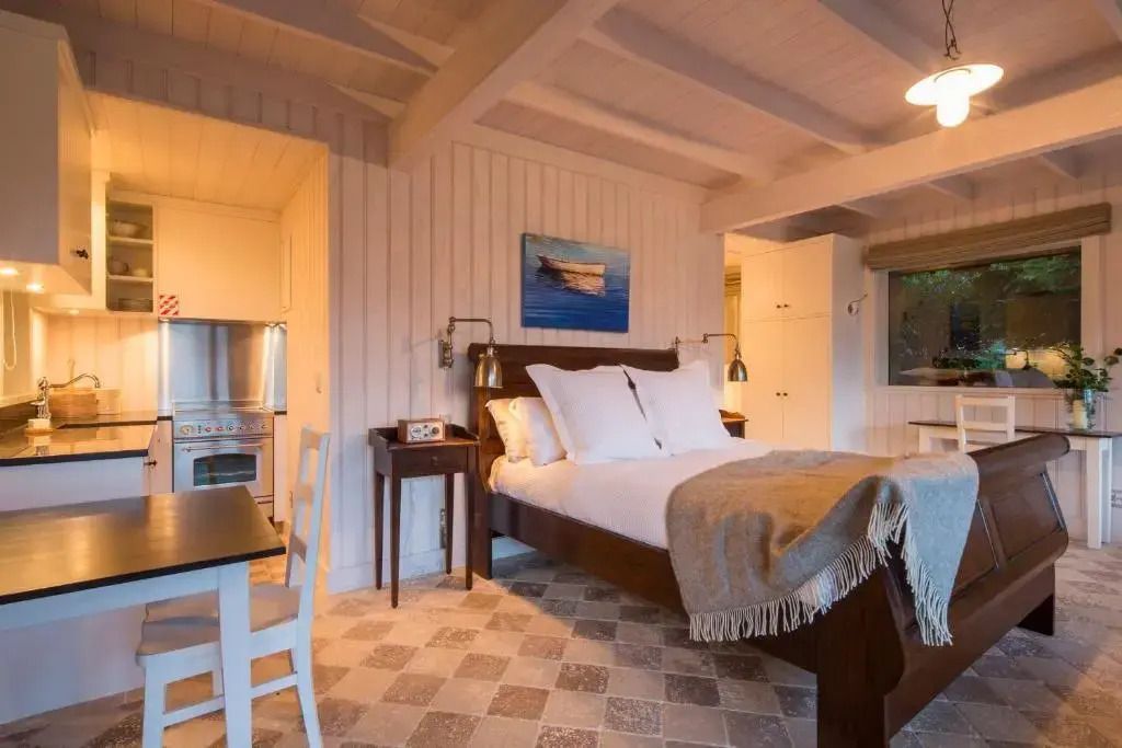 Gemütliches Schlafzimmer in der Deluxe Suite mit Holzakzenten und Kunstwerk an der Wand.