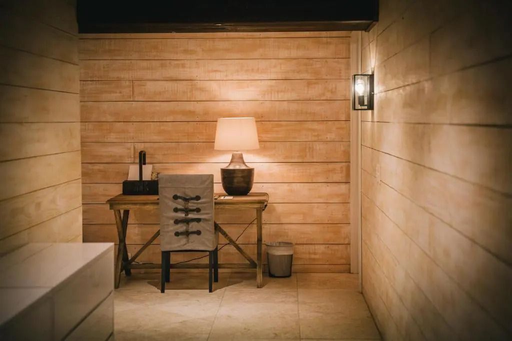 Schreibtisch mit Lampe in einem stilvollen Raum mit Holzverkleidung