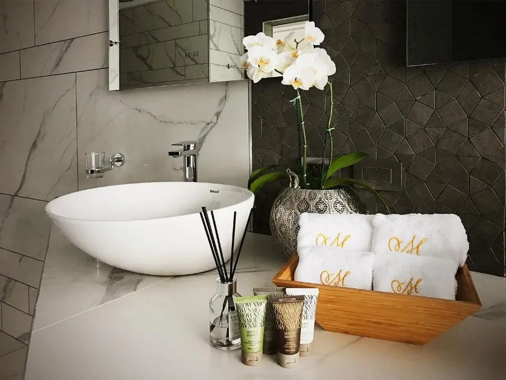 Modernes Badezimmer mit stilvollem Waschbecken und Orchidee im Dekor.