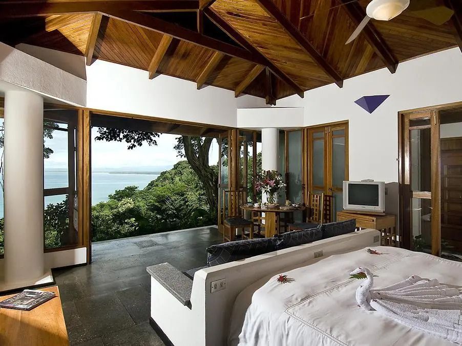 Luxuriöses Einzelstudio mit offenem Blick auf das Meer und bewaldete Hügel.