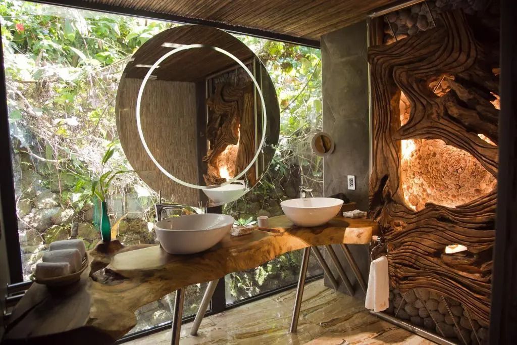 Elegantes Badezimmer mit zwei Waschbecken und Naturstein-Elementen sowie einem großen Spiegel