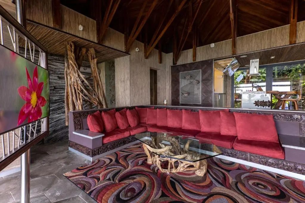 Großzügiger Wohnbereich mit rotem Sofa und einzigartigem Holztisch in luxuriöser Villa