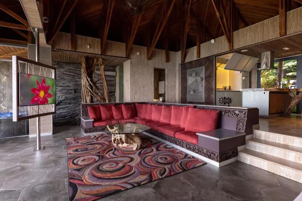 Wohnbereich mit kunstvollem Teppichdesign und rotem Sofa in exquisiter Villa