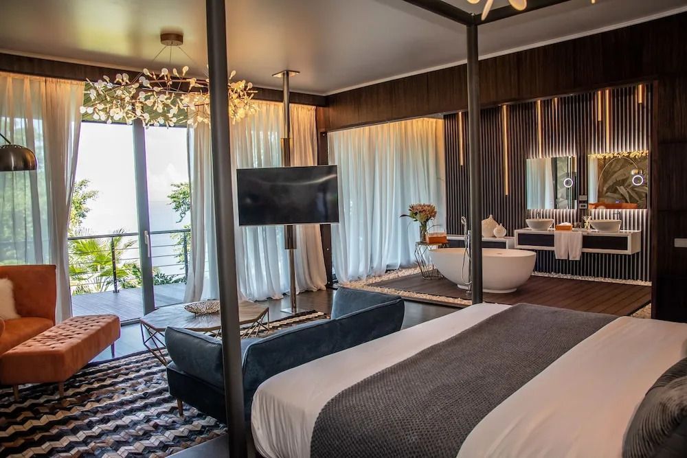 Elegantes Schlafzimmer mit Himmelbett und freistehender Badewanne