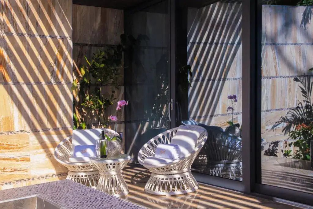 Gemütlicher Balkon mit zwei modernen Stühlen und Blick auf Pflanzen