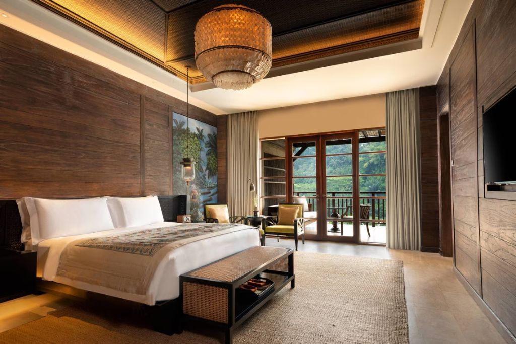 Luxus-Suite mit Doppelbett und Balkon mit Blick auf grüne Landschaft