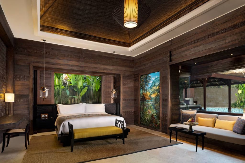 Luxuriöses Schlafzimmer mit Holzwänden und Kunstwerken in der Mandapa Pool Villa.