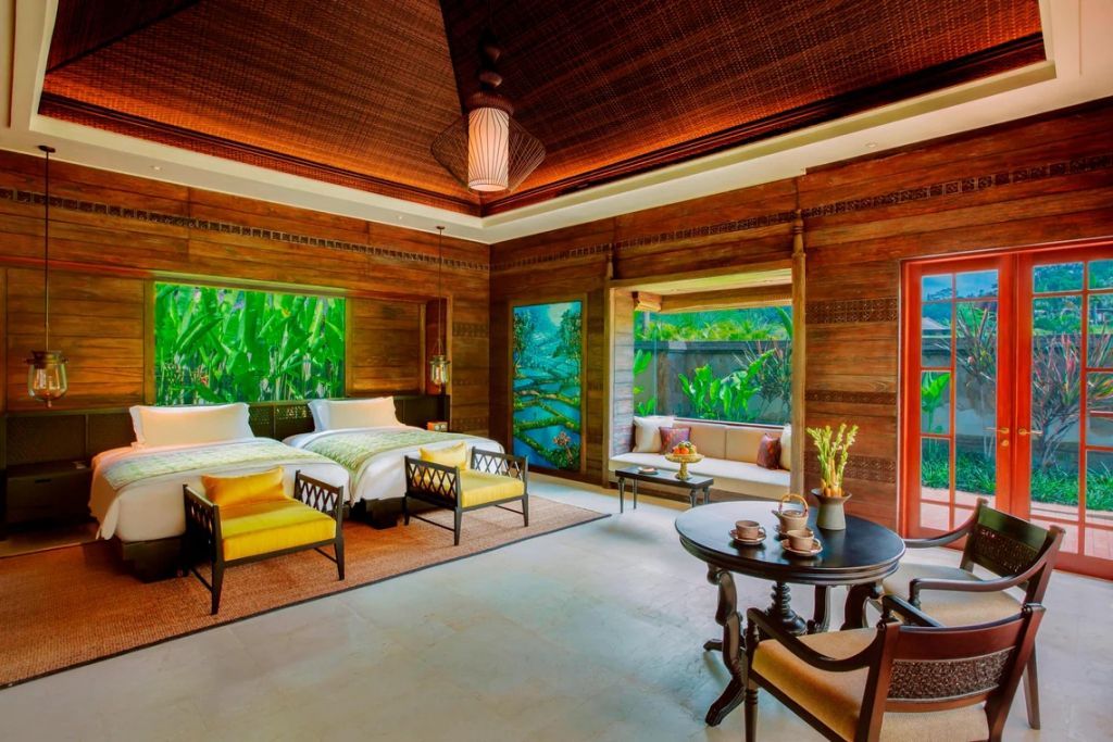 Geräumiges Schlafzimmer mit Sitzecke und Panoramafenstern in der Mandapa Pool Villa.