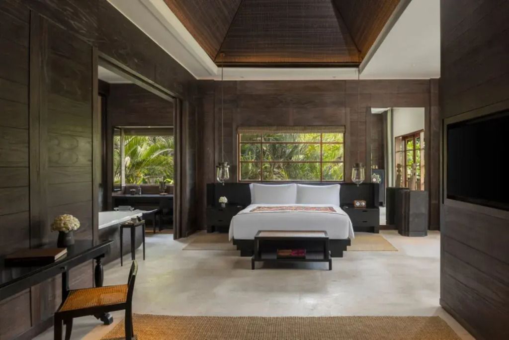 Luxuriöses Schlafzimmer mit großen Fenstern und Pflanzenblick