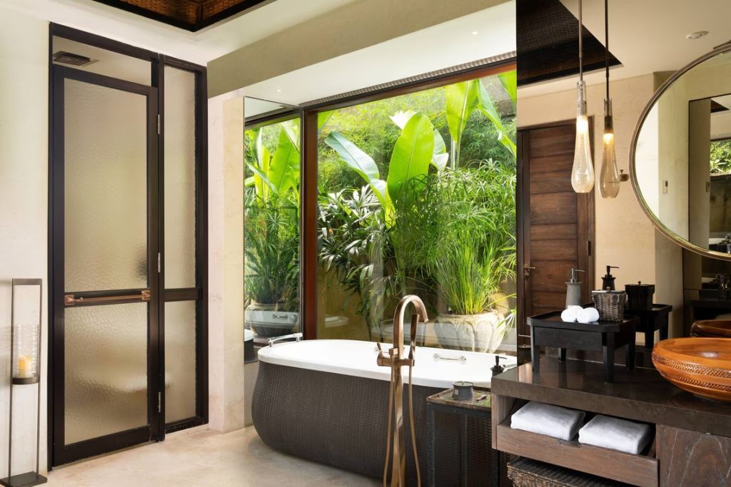 Modernes Badezimmer mit freistehender Badewanne und Blick ins Grüne