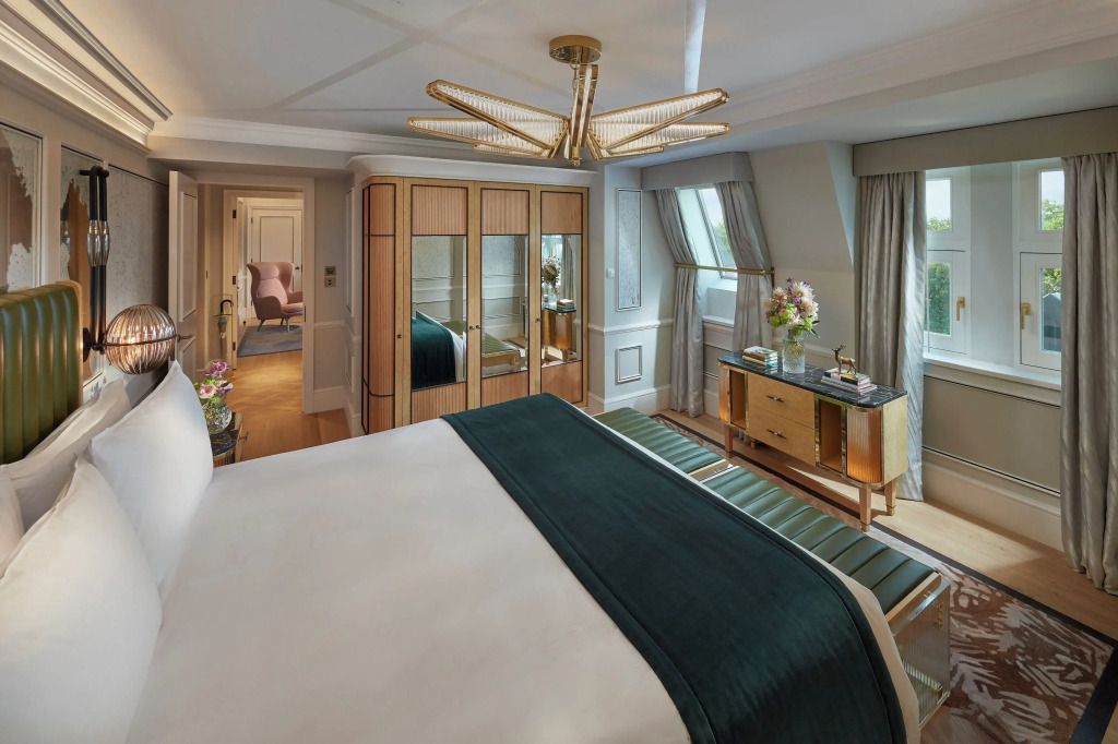 Elegantes Schlafzimmer der Family Hyde Park Suite mit luxuriösem Doppelbett und stilvoller Beleuchtung.