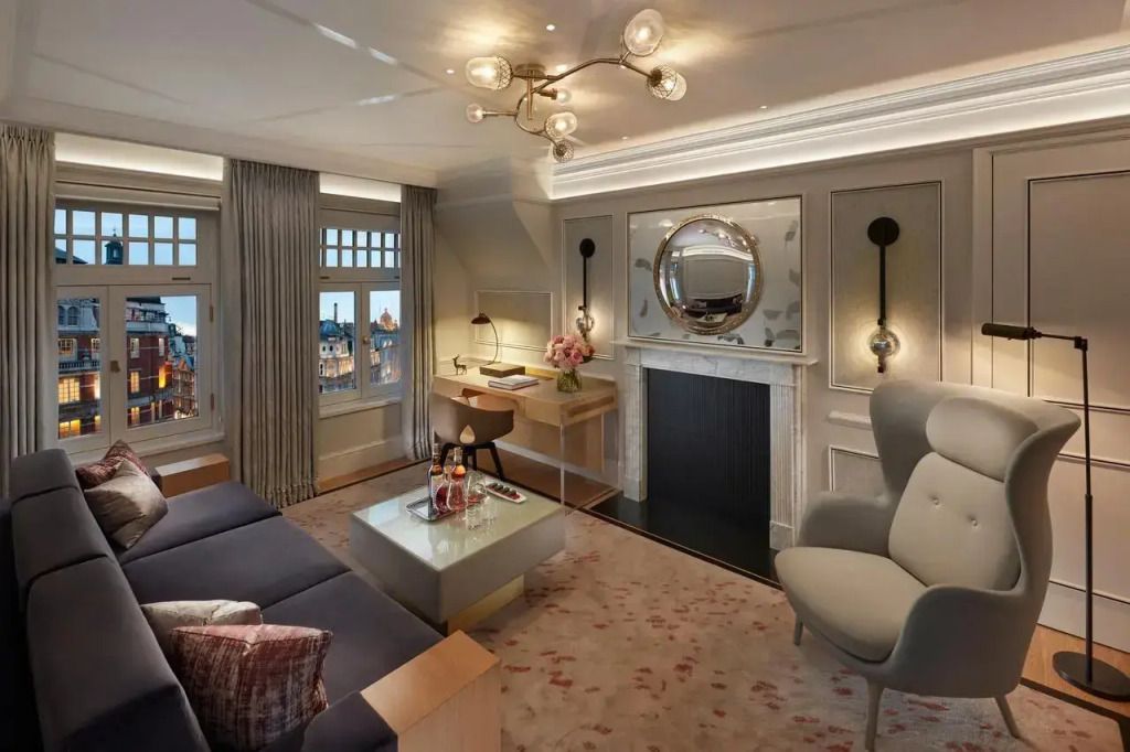 Wohnbereich der Suite mit modernem Kamin, gemütlicher Sitzecke und elegantem Schreibtisch