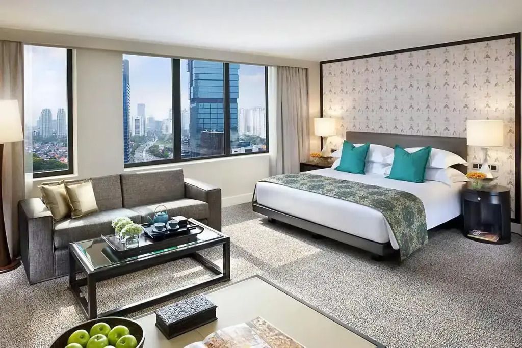 Elegantes Eckzimmer mit Doppelbett und Blick auf die Skyline von Jakarta