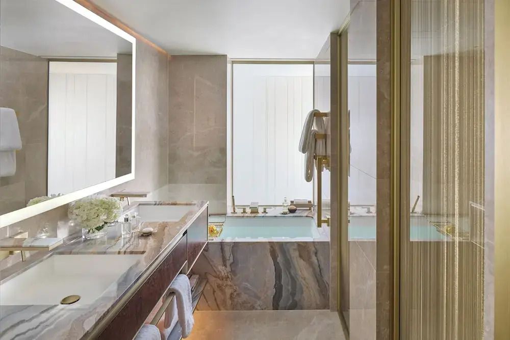 Luxuriöses Badezimmer mit Marmoroberflächen und großer Badewanne.