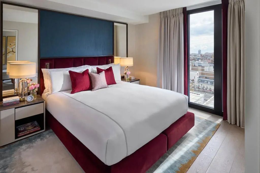 Schlafzimmer mit großem Fenster und Blick auf die Stadt