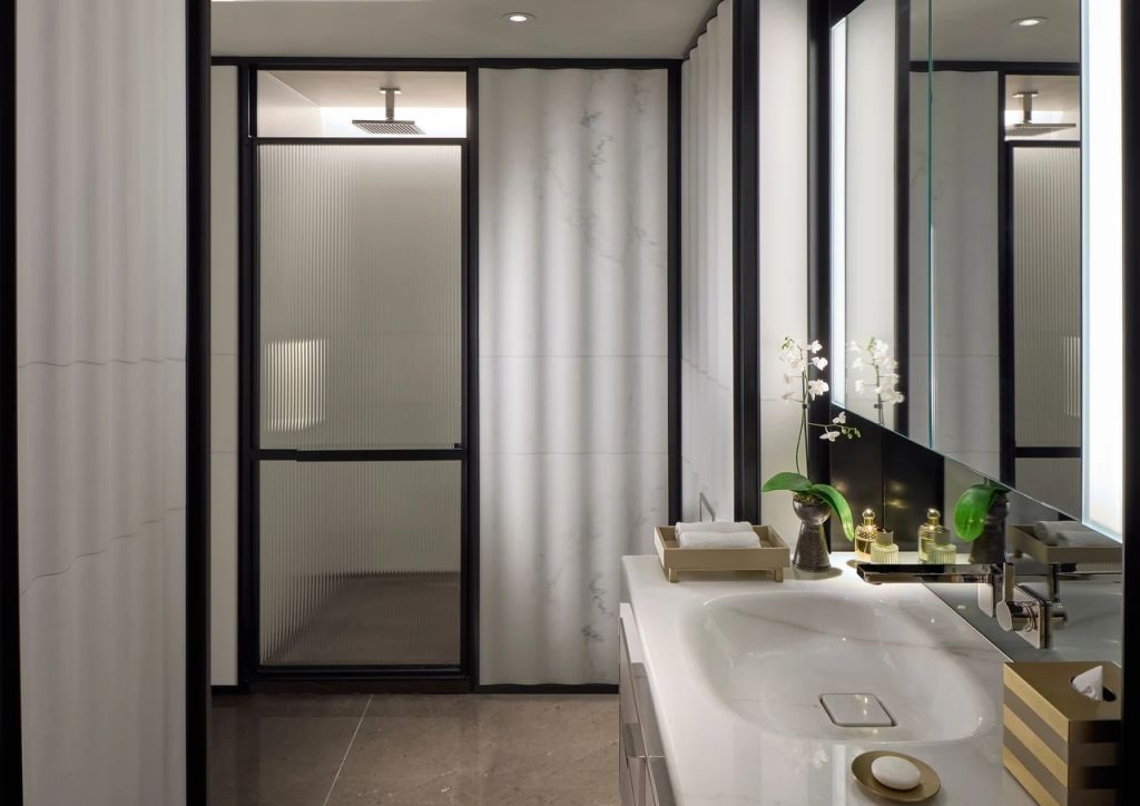 Modernes Badezimmer mit Glasdusche und eleganter Waschtischplatte