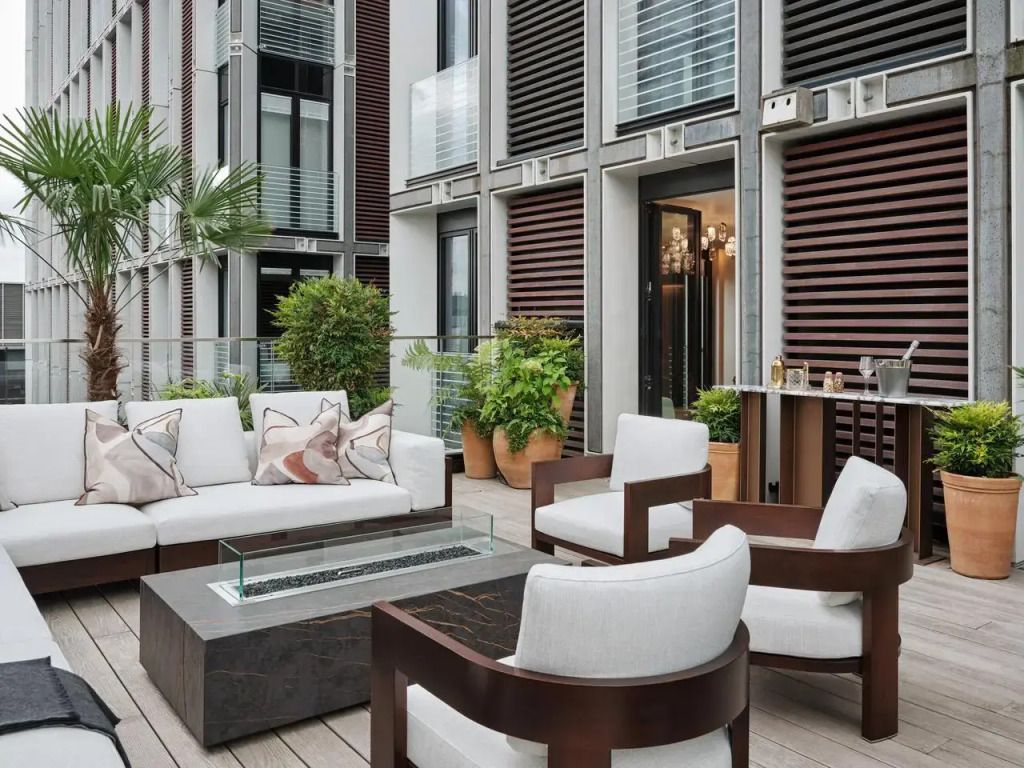 Luxe Terrasse mit stilvollen Möbeln und üppiger Begrünung, urbaner Hintergrund.