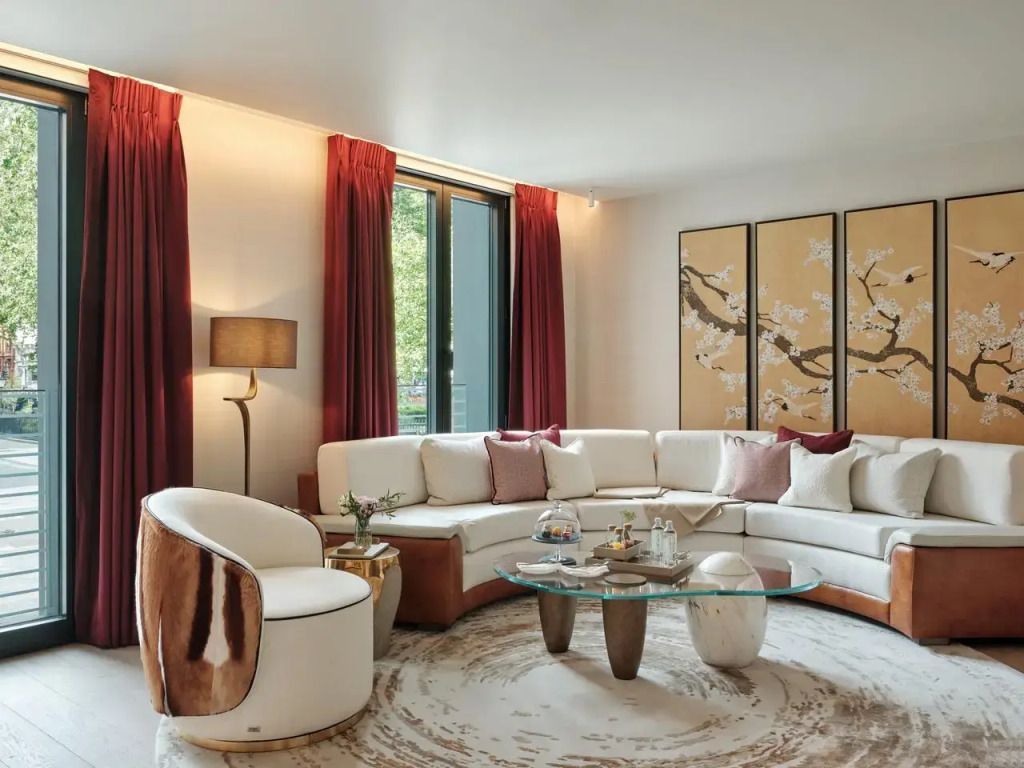 Geräumiges Wohnzimmer mit heller Sofalandschaft und dekorativen Kunstwerken.