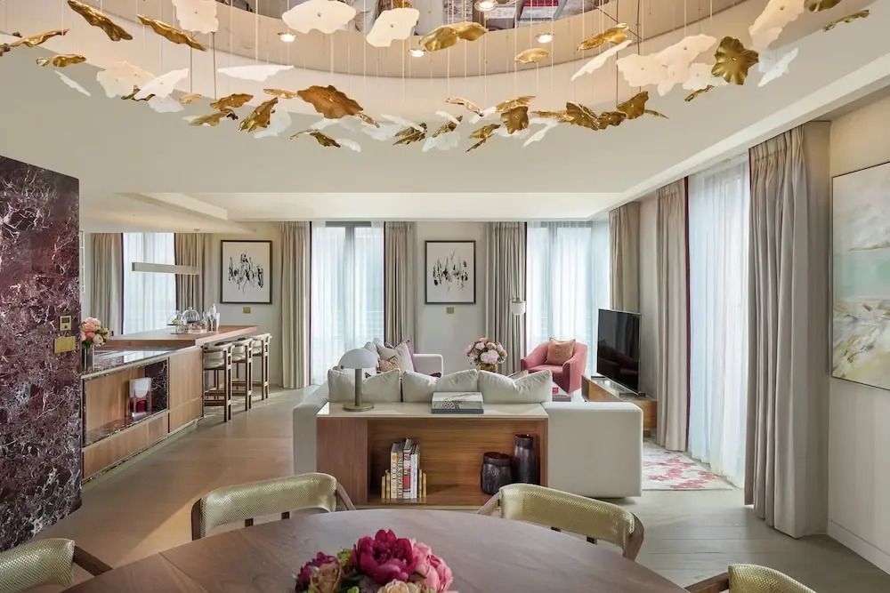 Offener Wohnbereich mit luxuriösem Dekor und goldenen Design-Elementen an der Decke.