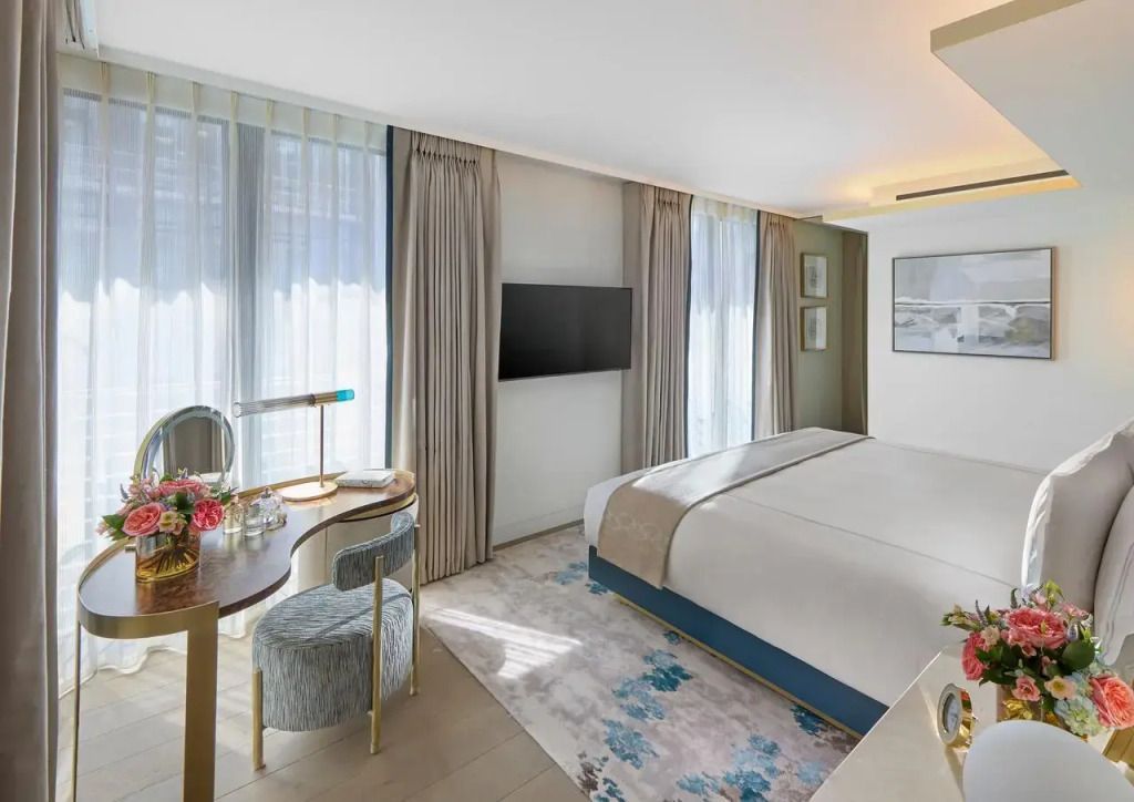 Helles und luxuriöses Hotelzimmer mit Doppelbett und großen Fenstern