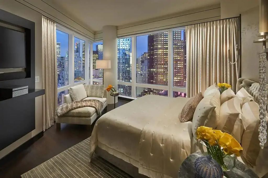 Elegantes Schlafzimmer mit Aussicht auf die Skyline von New York City bei Nacht