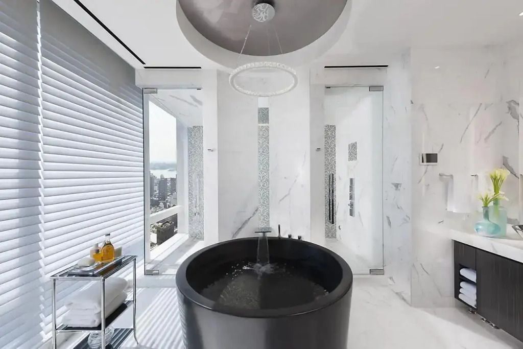 Luxuriöses Badezimmer mit freistehender Badewanne und Stadtblick