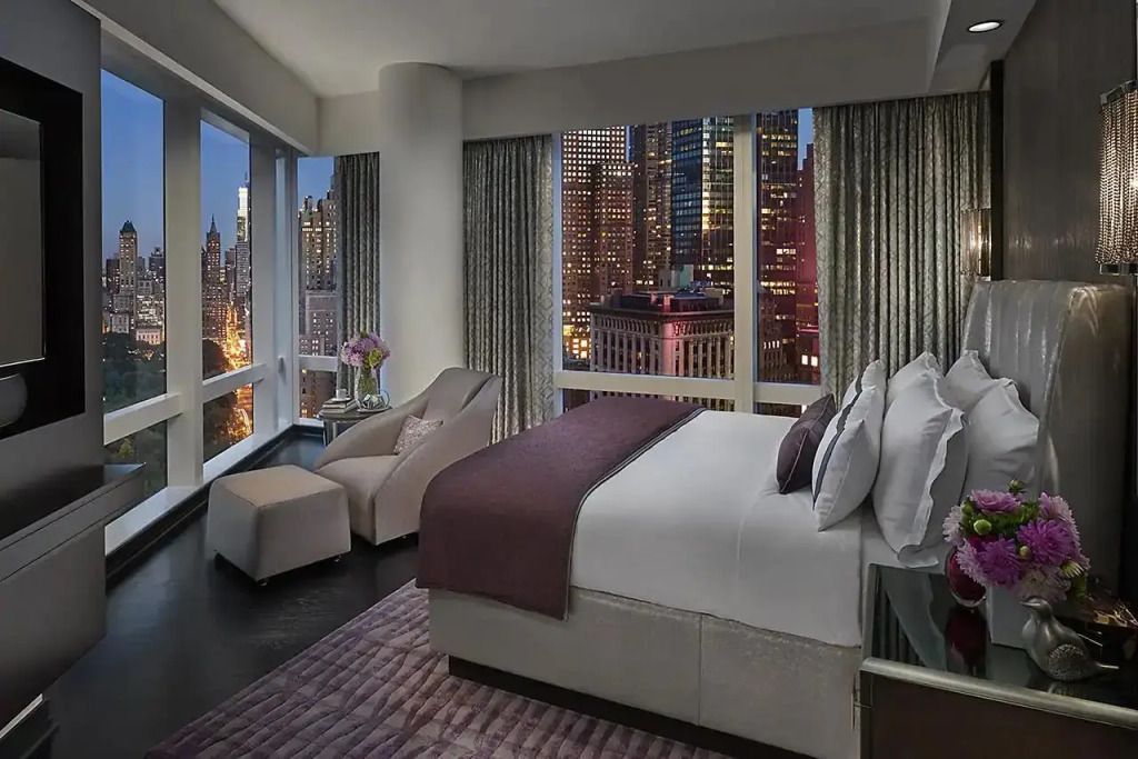 Geräumiges Schlafzimmer mit Panoramablick auf die Stadt bei Dämmerung