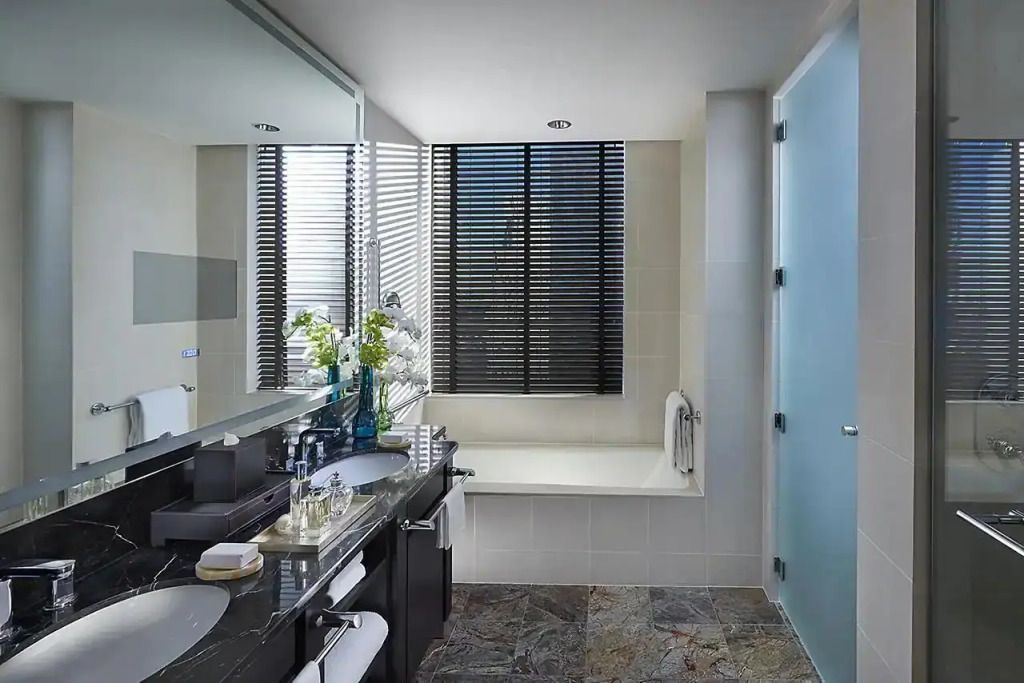 Modernes Badezimmer mit weißer Badewanne und großer Spiegelwand