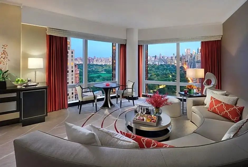 Geräumiges Wohnzimmer einer Suite mit großen Fenstern und Blick auf Central Park