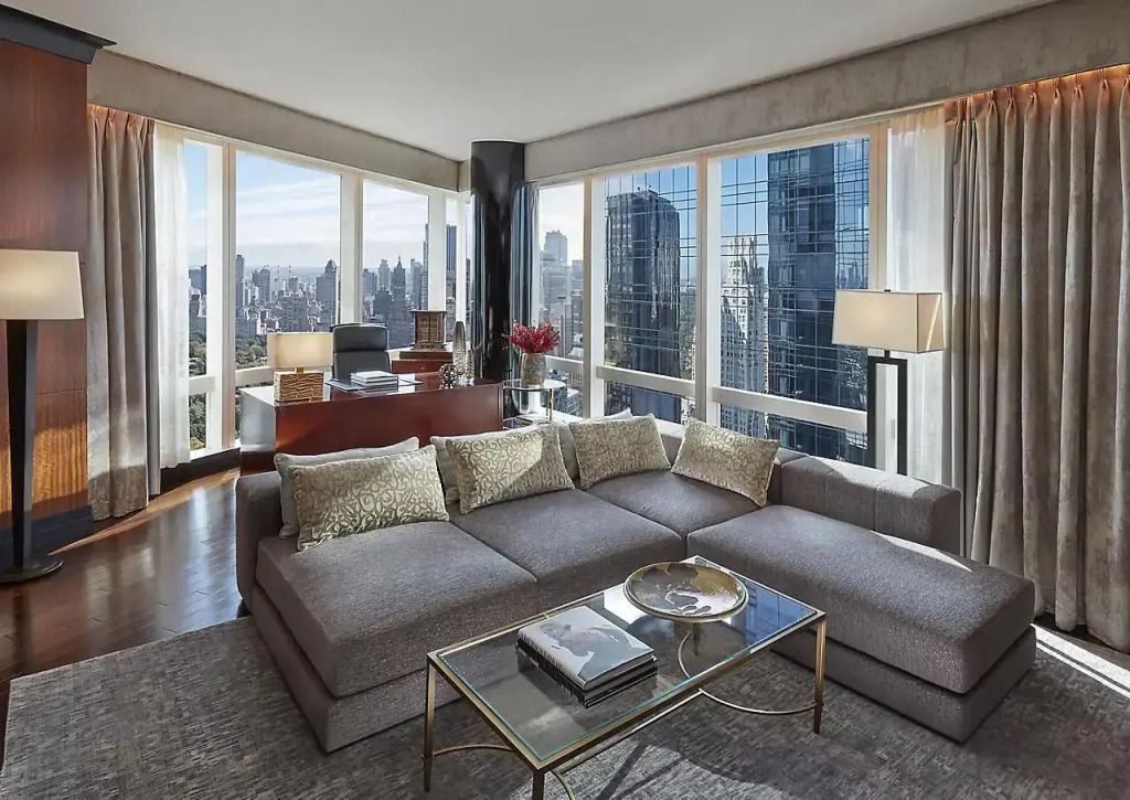 Großzügiger Wohnbereich mit modernen Möbeln und Panoramafenster in der Suite.