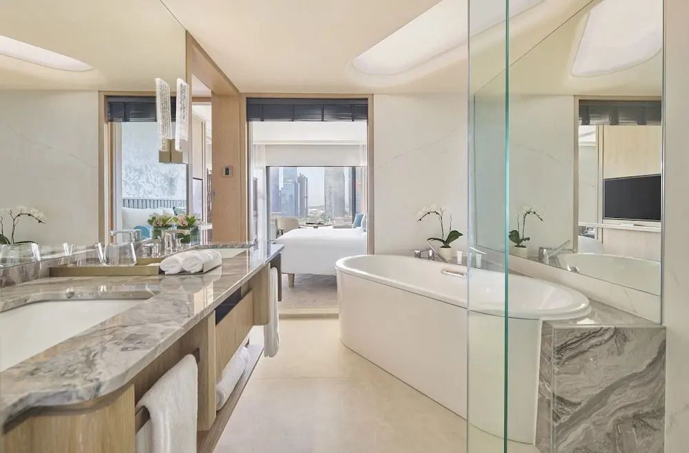 Luxuriöses Badezimmer mit moderner Ausstattung und freistehender Badewanne im Club Marina Bay Zimmer