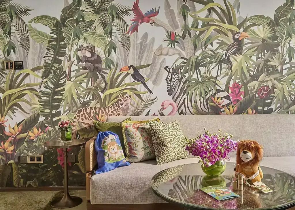 Sitzbereich mit exotischem Dschungel-Wandbild und eleganter Blumendekoration