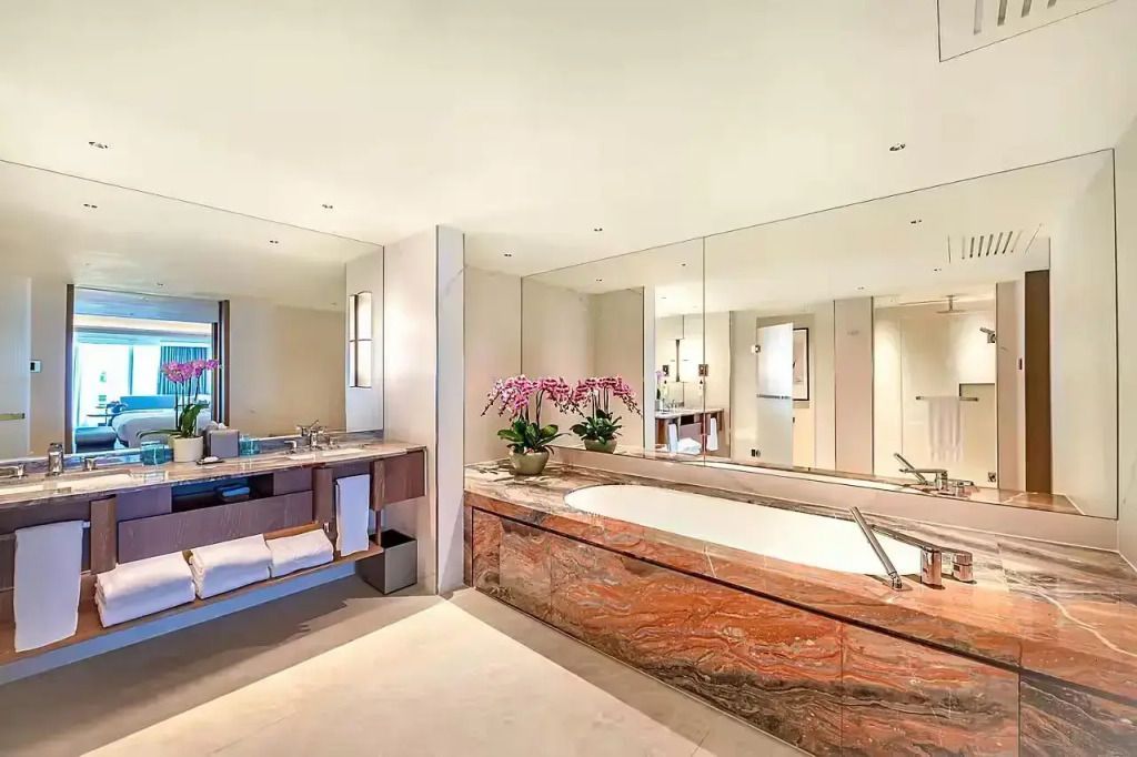 Luxuriöses Badezimmer mit großer Badewanne und modernen Annehmlichkeiten im Mandarin Oriental Singapore