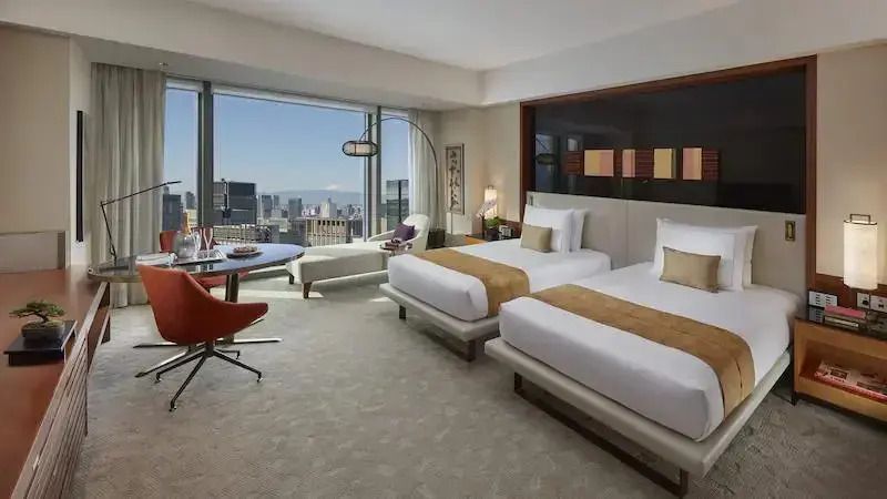 Deluxe Zimmer mit zwei Einzelbetten und Aussicht auf die Skyline von Tokyo.