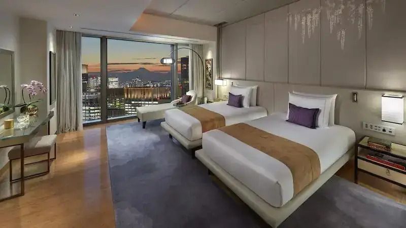 Luxuriöse Suite mit zwei Einzelbetten und beeindruckendem Stadtblick bei Nacht