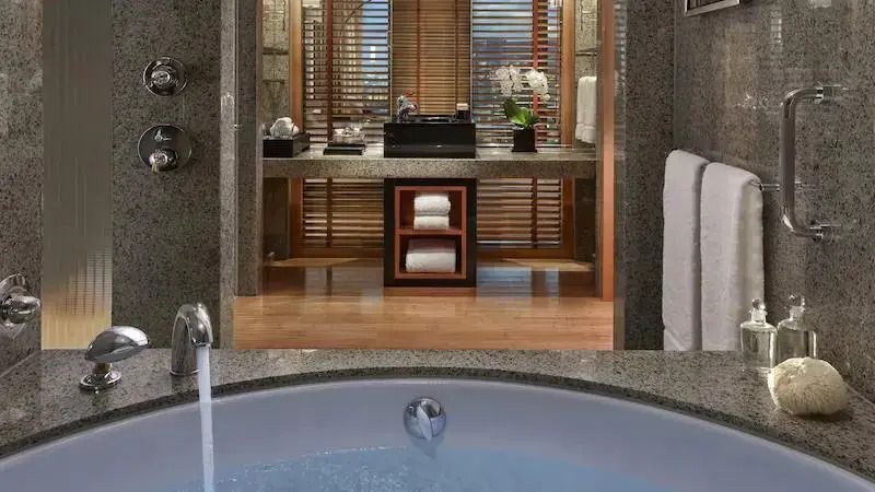 Modernes Badezimmer mit Whirlpool und hochwertiger Ausstattung aus edlem Marmor