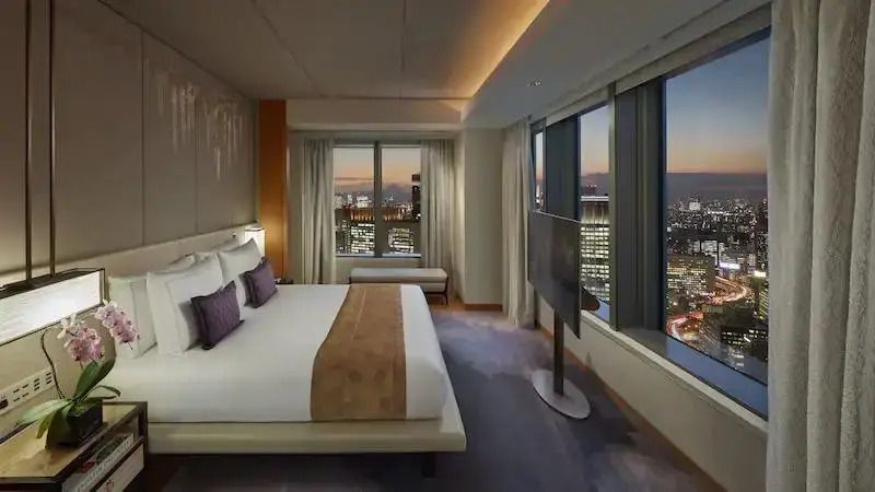 Luxuriöses Schlafzimmer in der Oriental Suite mit Stadtblick bei Sonnenuntergang
