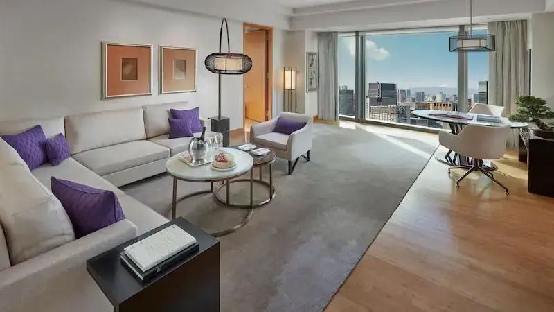 Helles Wohnzimmer in der Premier Doppel Suite mit Panoramafenstern und stilvoller Einrichtung