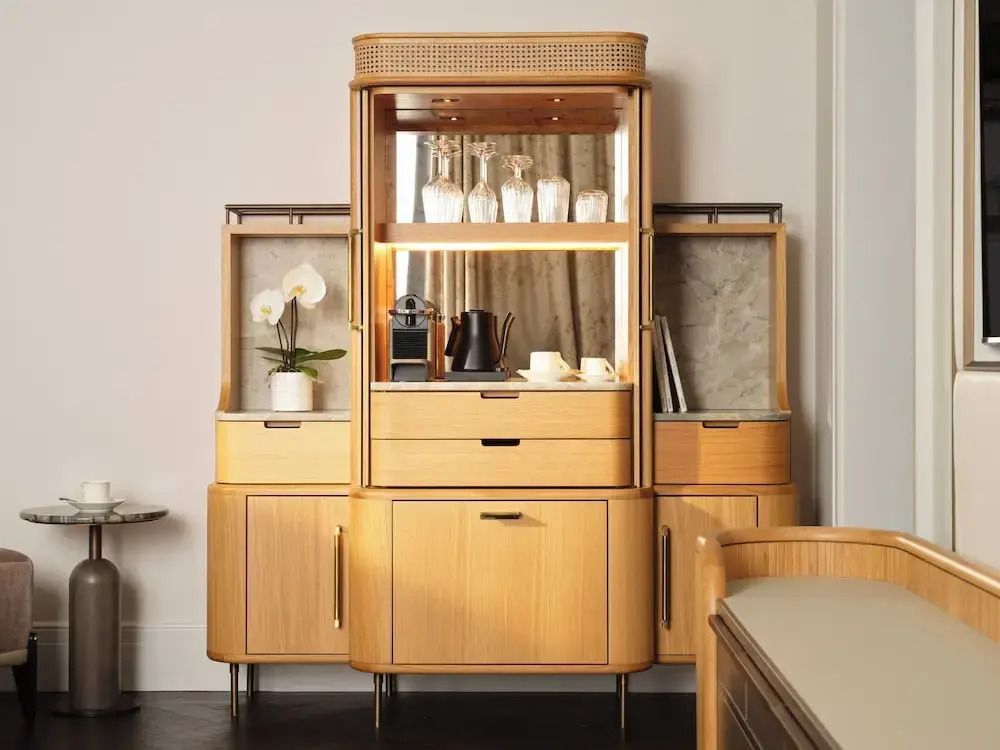 Luxuriöse Minibar mit hochwertiger Kaffeemaschine und stilvollen Holzschränken