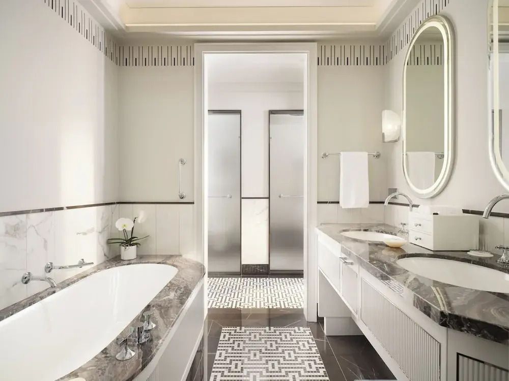 Helles Badezimmer mit Marmoroberflächen und luxuriöser Ausstattung in der Suite.