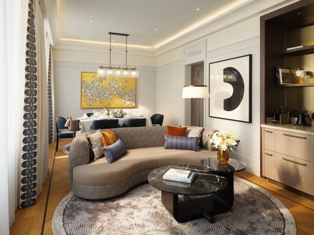 Wohnbereich mit geschwungener Couch und stilvollem Dekor in der Suite.