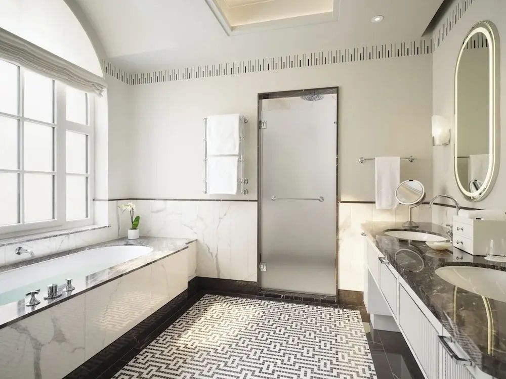Luxuriöses Badezimmer mit Badewanne und moderner Glasdusche.