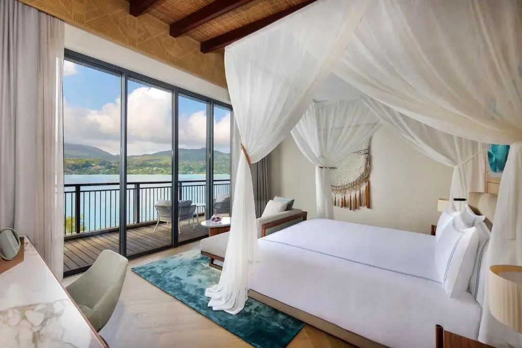 Helles Schlafzimmer mit Meerblick, Himmelbett und Zugang zu einem Balkon