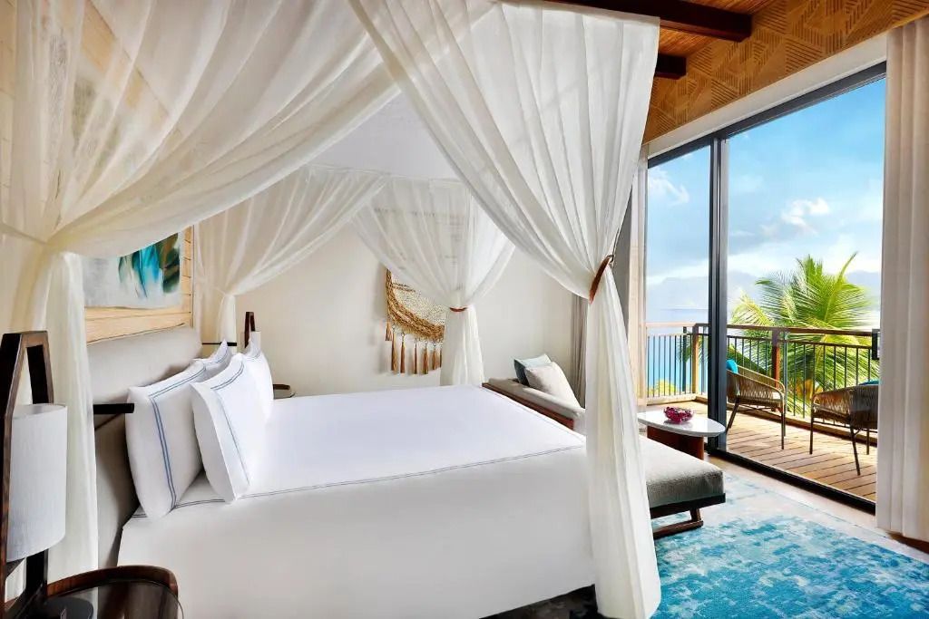 Doppelzimmer mit Himmelbett und Meerblick im Mango House Seychelles