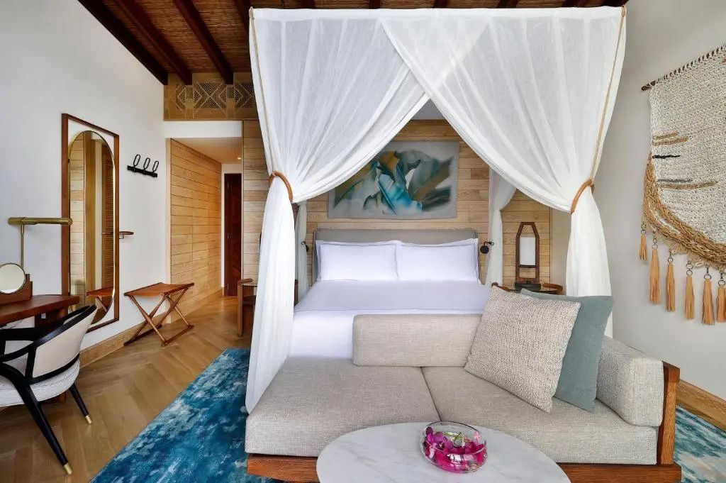 Sitzbereich und Doppelbett im Premium-Zimmer mit stilvoller Einrichtung