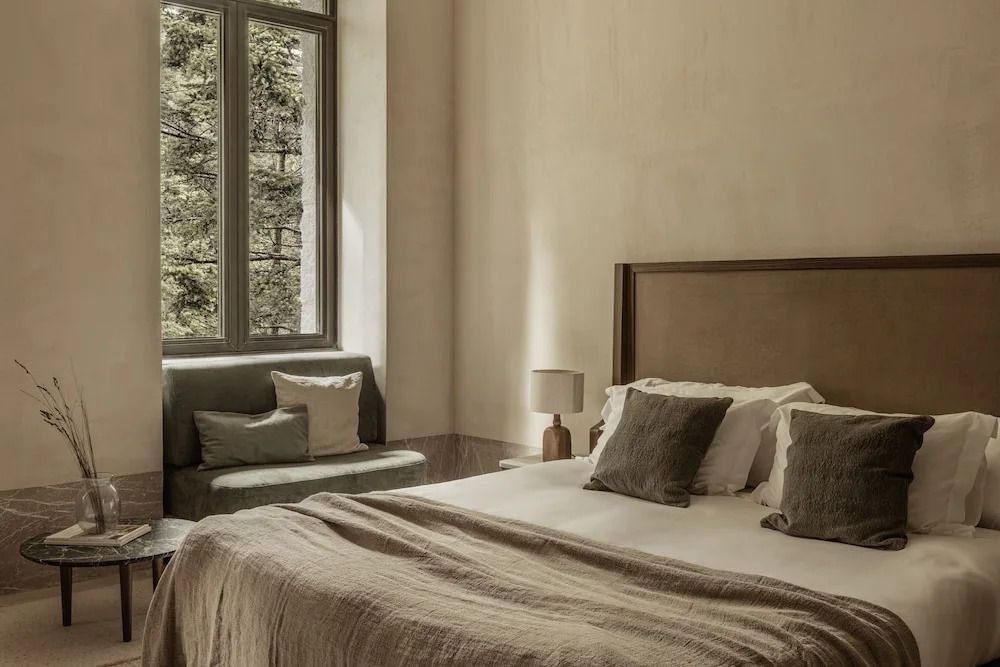 Komfortables Doppelbett im lichtdurchfluteten Zimmer mit Sofa