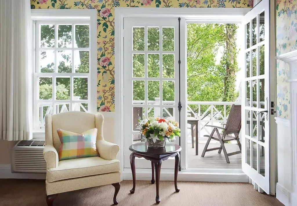 Sitzbereich mit Sessel, Tisch und Blick auf Balkon mit Gartenmöbeln