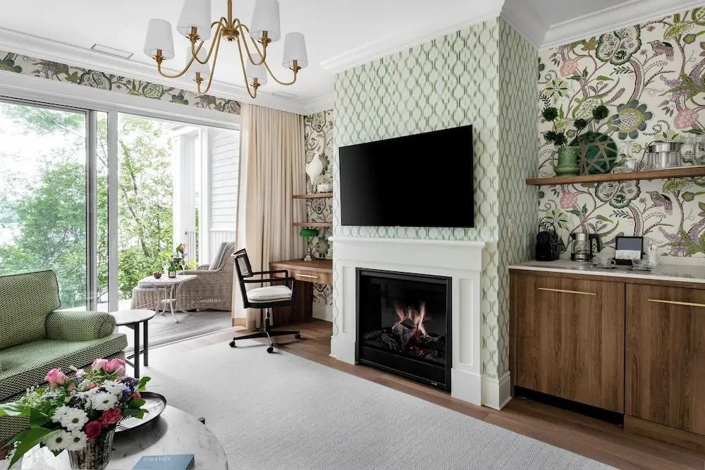 Suite mit Kamin, TV und Schreibtisch vor floralem Tapetenmuster