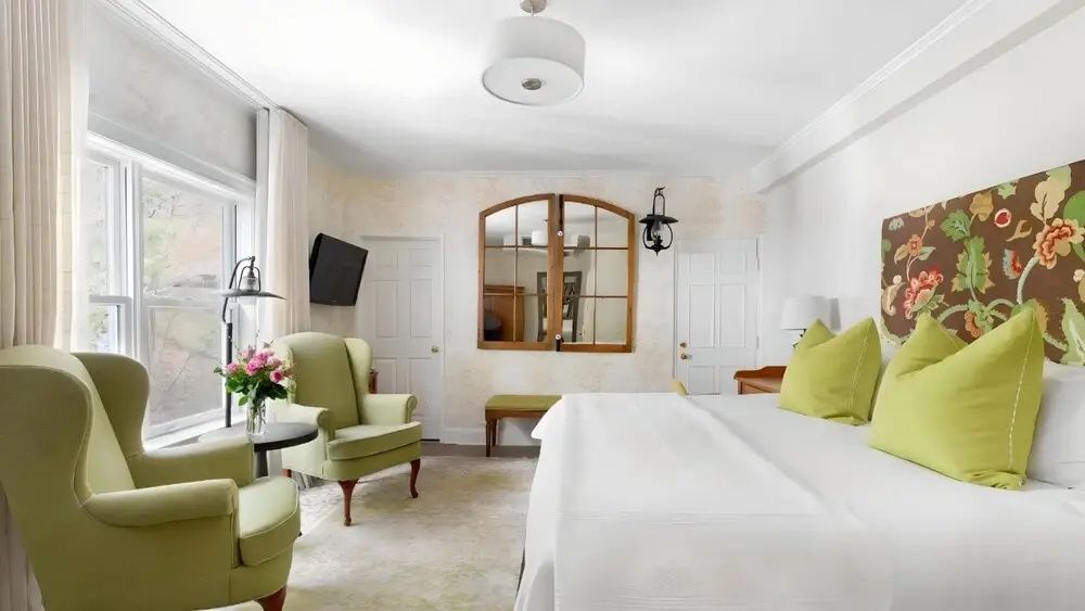 Klassisch eingerichtetes Zimmer mit Doppelbett und beige-grüner Dekoration